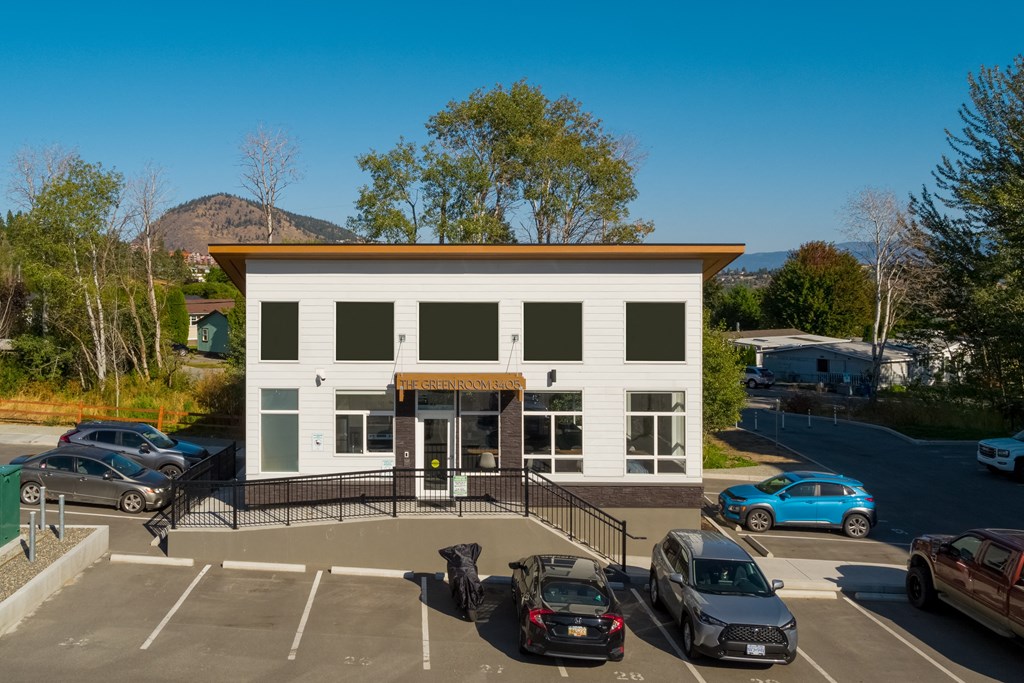 a small white building with a parking lot in front of it