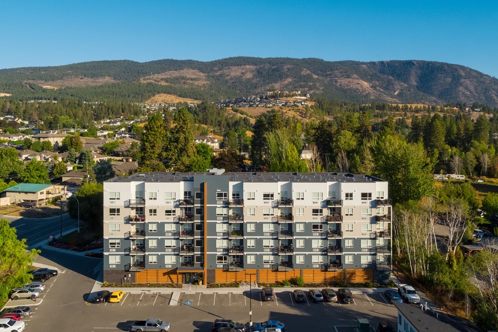 an aerial view of an apartment building with a mountain in the background