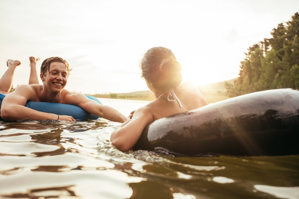 Two people are floating on a surfboard in the water.
