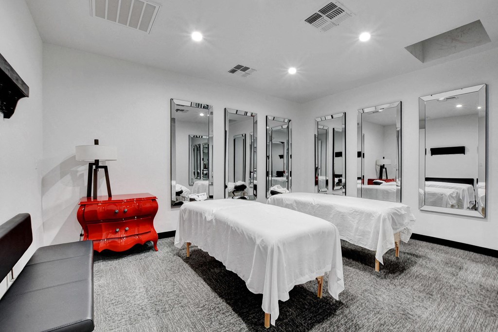 two beds in a room with mirrors and a red suitcase at Evoq Apartment Homes, Las Vegas  
