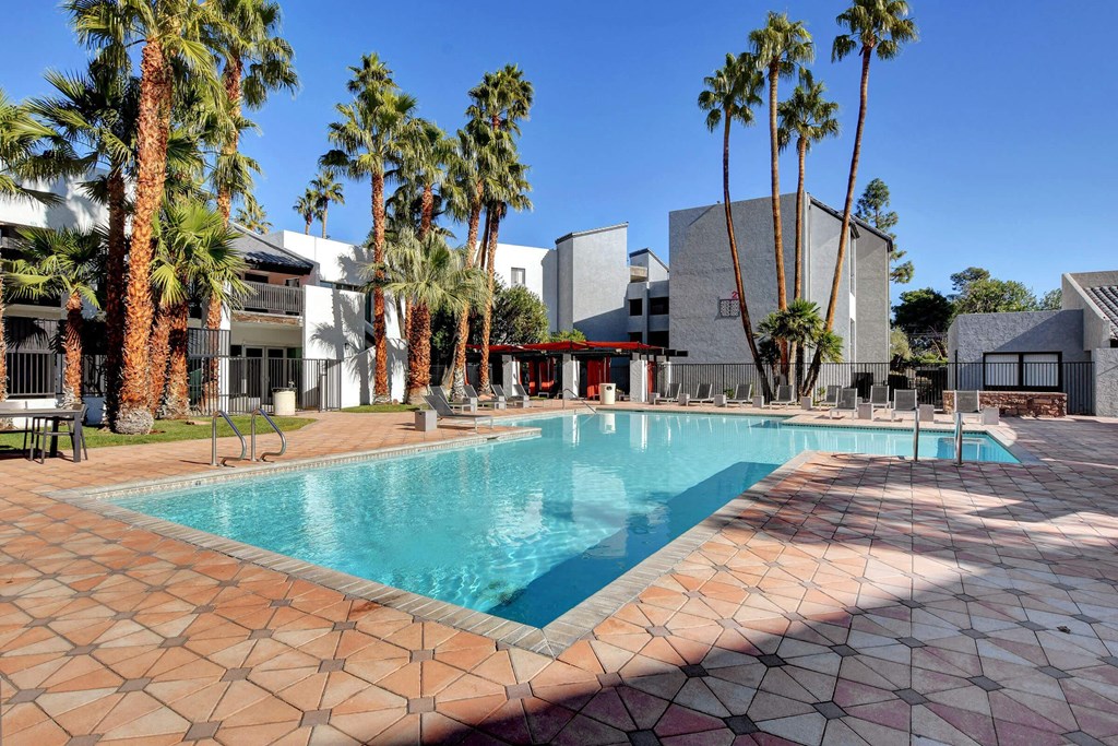 a large swimming pool in front of a hotel with palm trees at Evoq Apartment Homes, Nevada, 89169