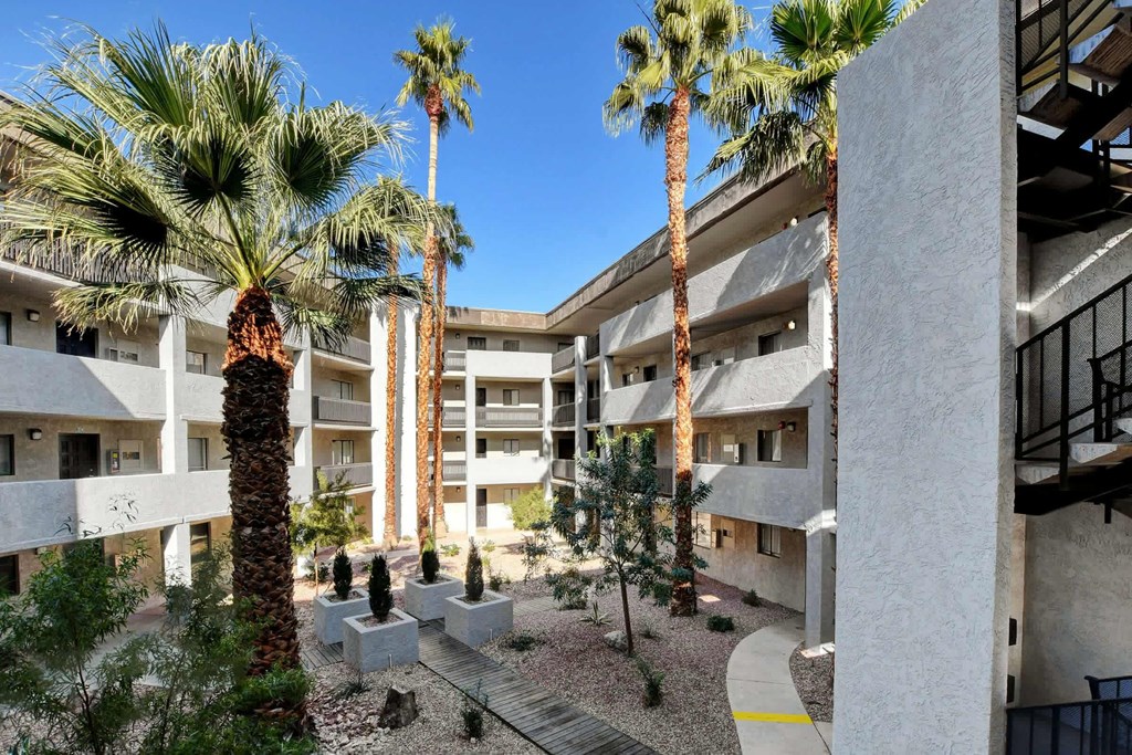 a view of a building with palm trees at Evoq Apartment Homes, Las Vegas, NV  
