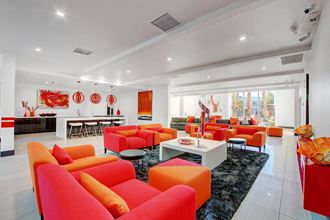 a living room with orange couches and chairs and a table