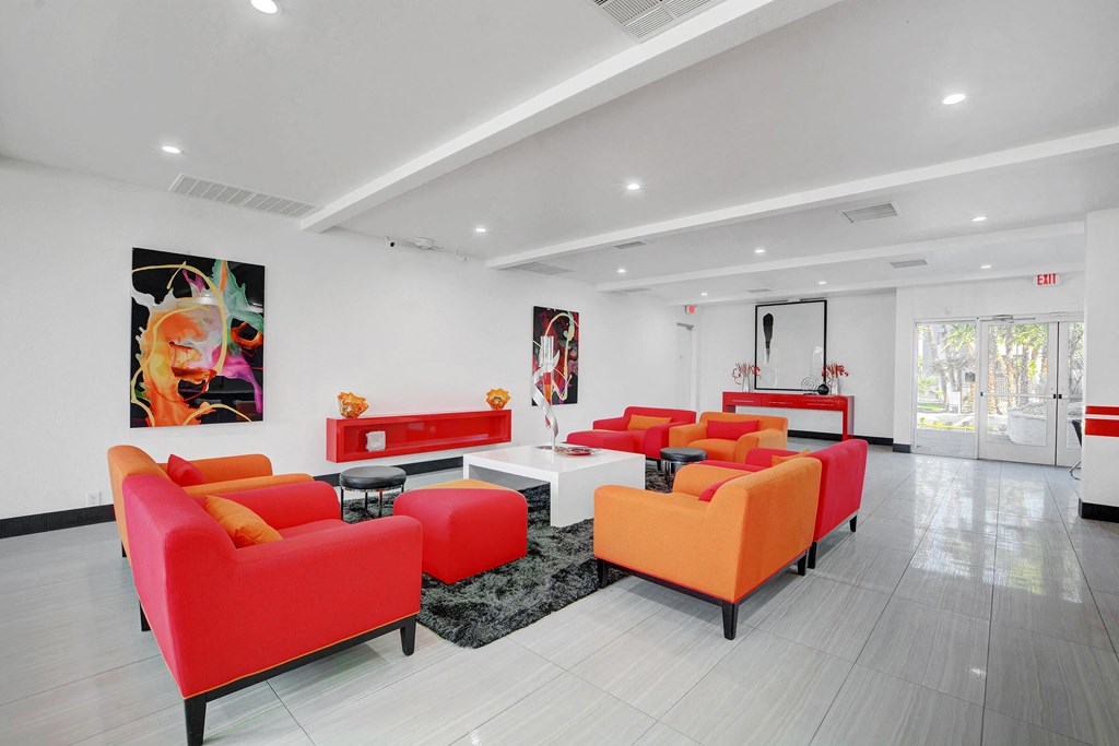 a living room with red and orange furniture and white walls at Evoq Apartment Homes, Las Vegas  