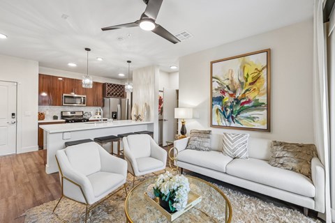 A living room with a white couch, a coffee table, and a painting on the wall.
