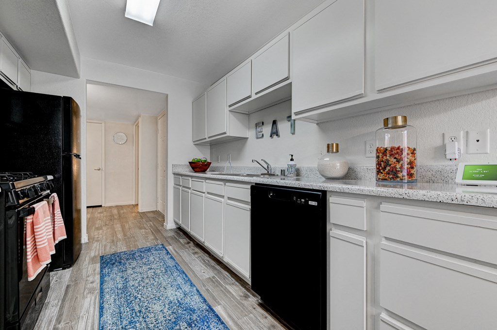 a kitchen with white cabinets and black appliances