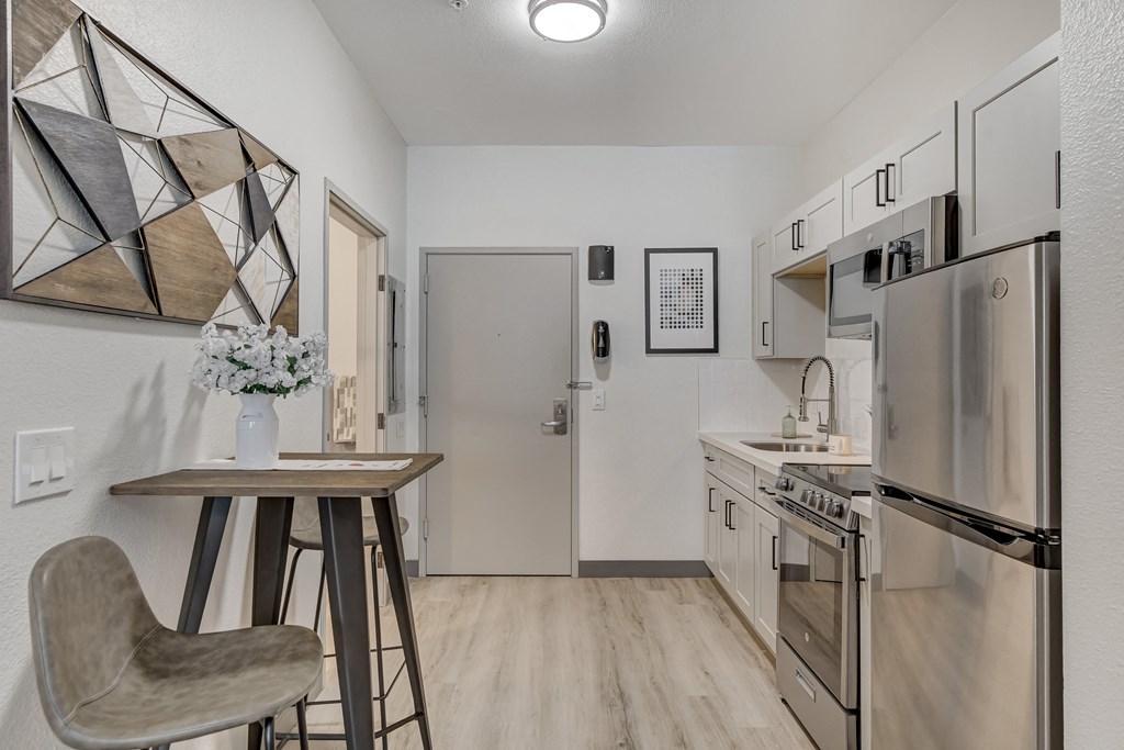 a kitchen with a refrigerator freezer next to a stove top oven