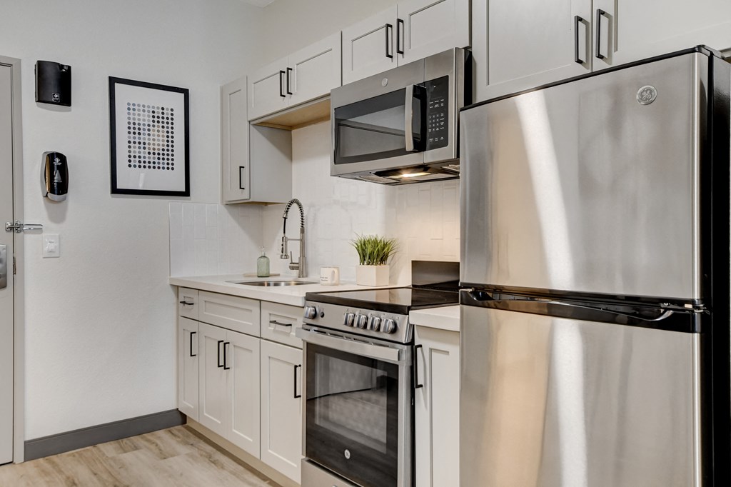a kitchen with white cabinetry and stainless steel appliances