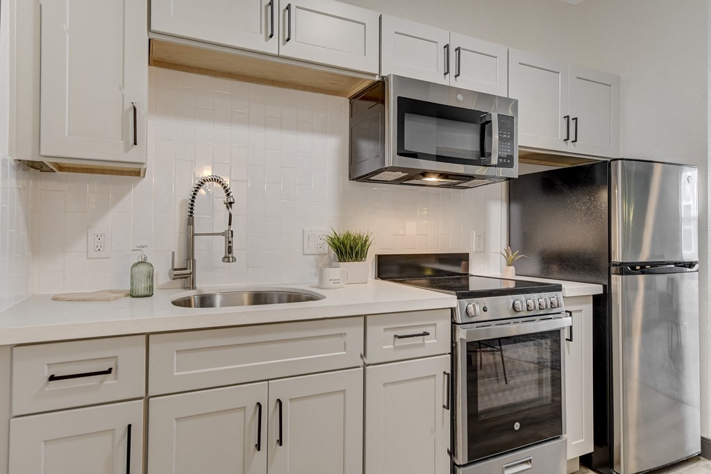 a kitchen with white cabinets and stainless steel appliances