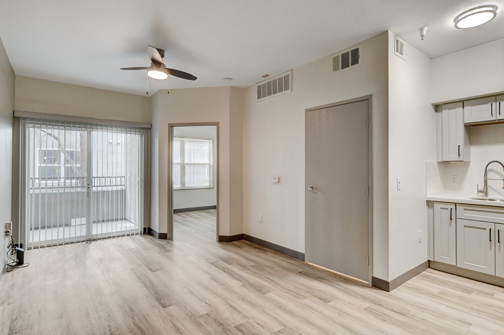 a bedroom with a large window and a ceiling fan