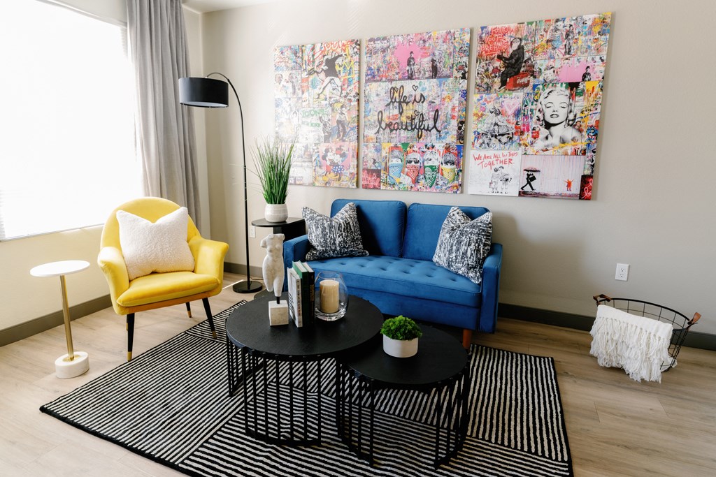 a living room with a blue couch and yellow chairs