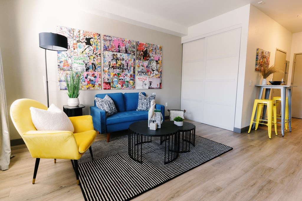 a living room with a blue couch and yellow chairs