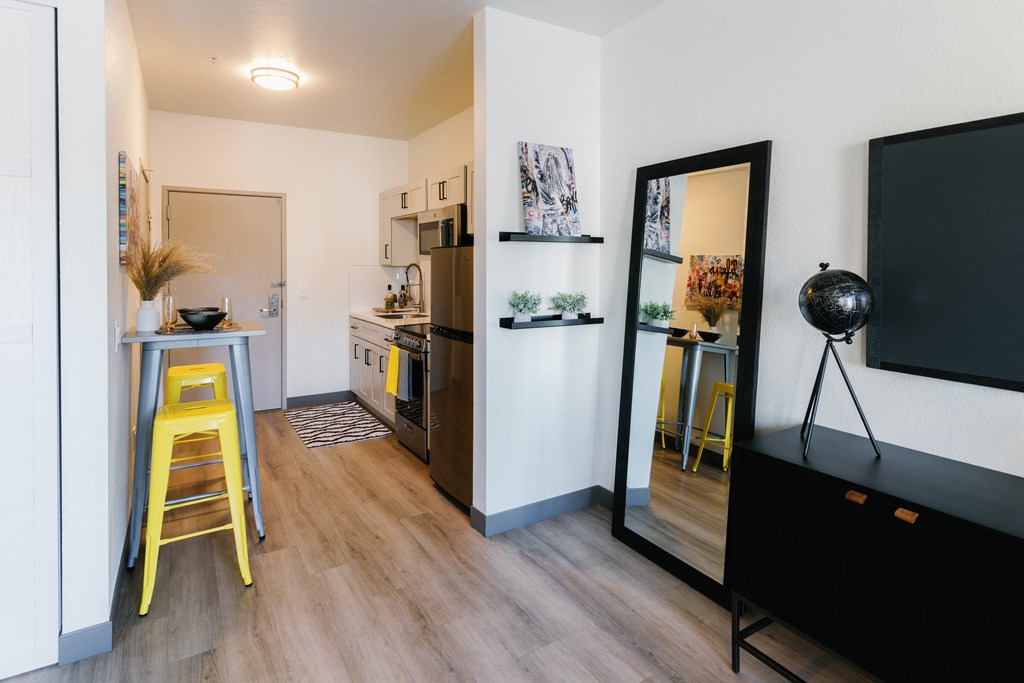 a living room and kitchen with a tv and a mirror