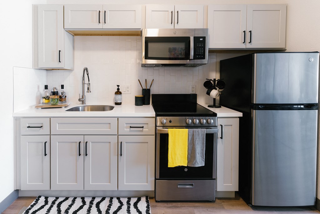 a kitchen with white cabinets and stainless steel appliances