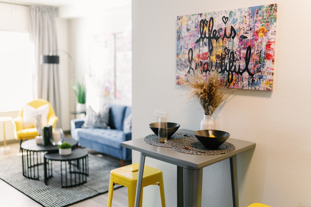 a living room with a table and a painting on the wall