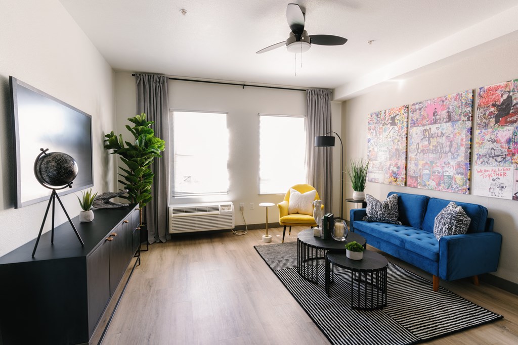 a living room with a blue couch and a yellow chair