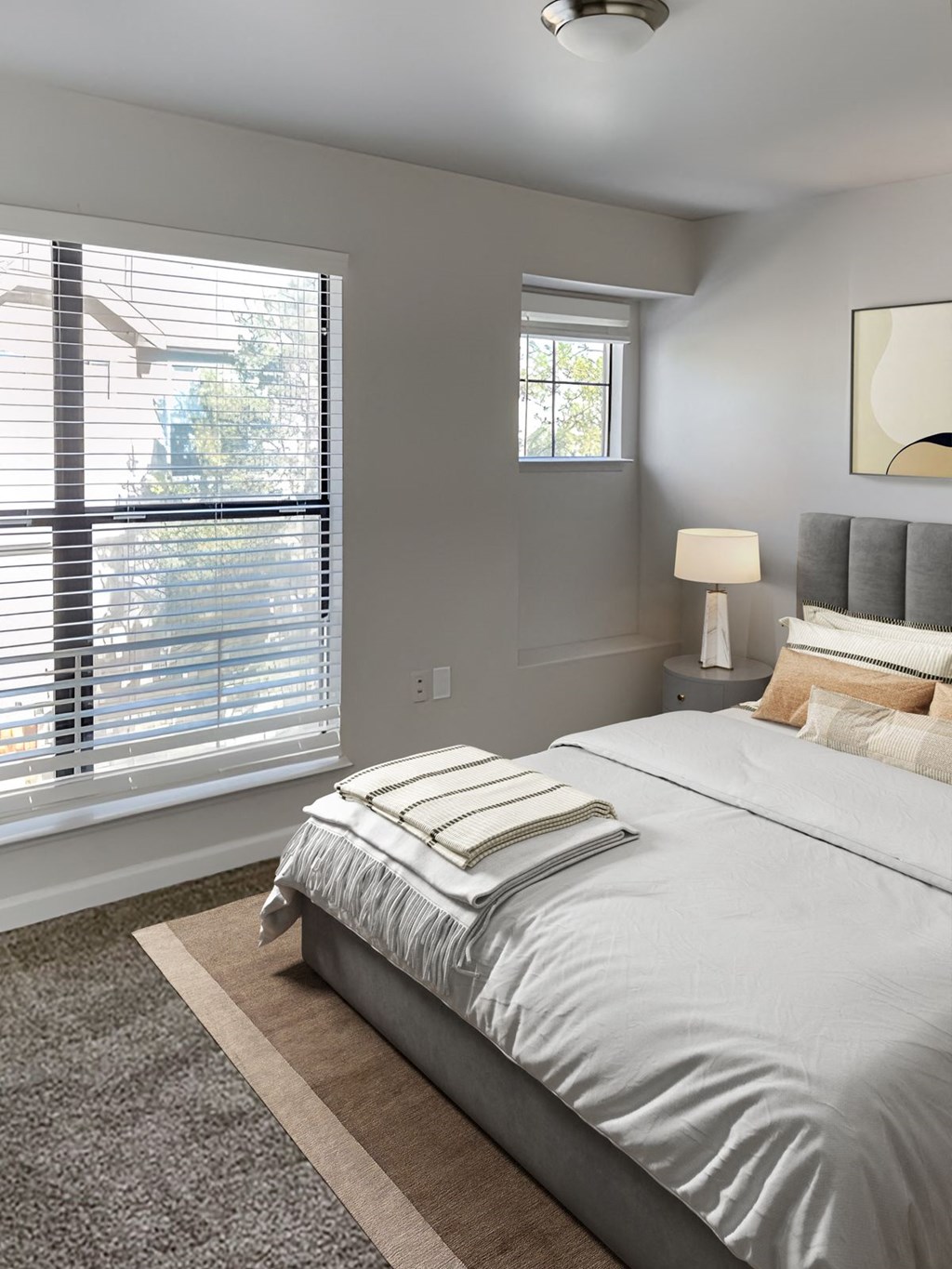 a bedroom with a large bed and two windows