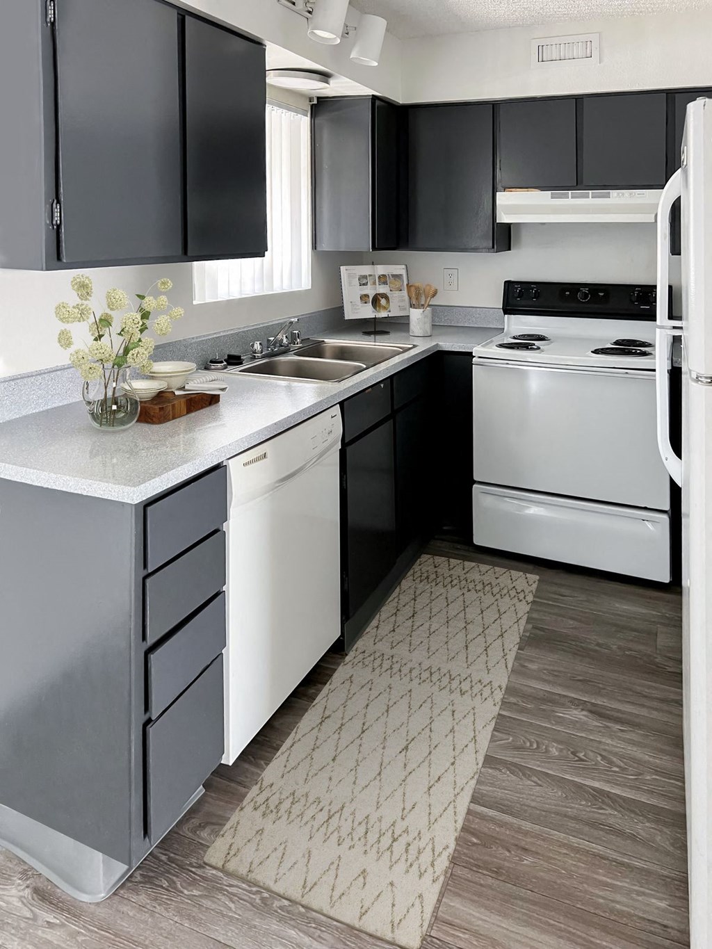 a kitchen with white appliances and black cabinets at Evoq Apartment Homes, Las Vegas, 89169  