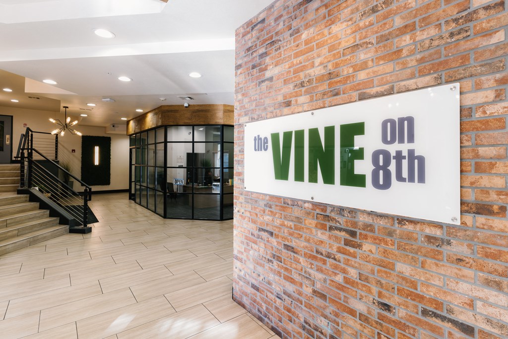 the lobby of the vine on 8th building with a sign on a brick wall