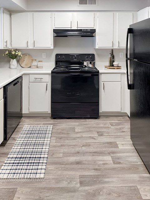 a kitchen with white cabinets and a black stove and refrigerator