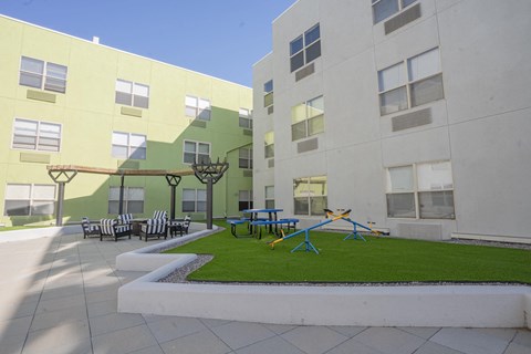 a courtyard with a playground and tables and chairs in an apartment building at The Onyx at 695, Nevada, 89503