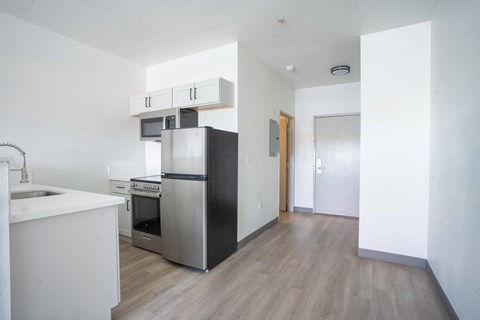 an empty kitchen with a refrigerator and a sink at The Onyx at 695, Nevada