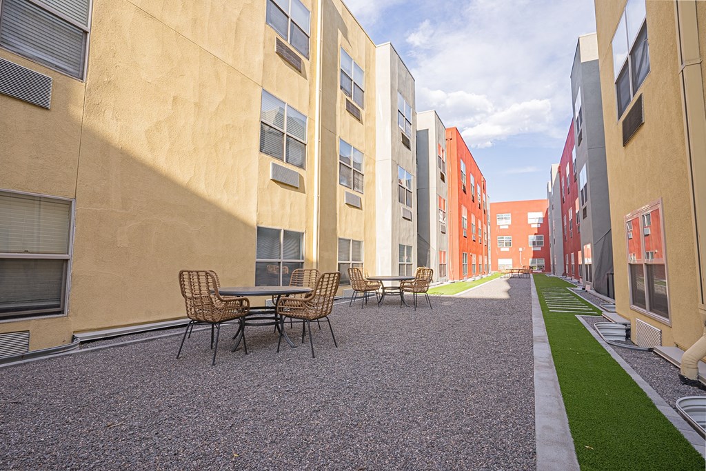 a courtyard with tables and chairs in a row of apartment buildings at ParcOne60, Reno, 89501