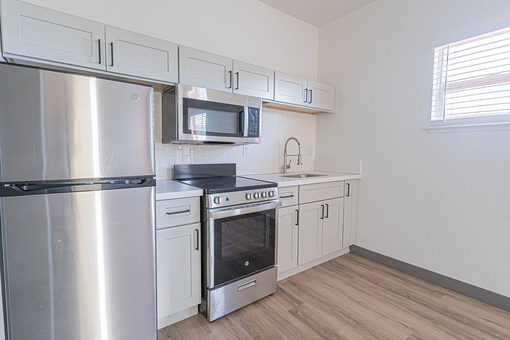 an empty kitchen with stainless steel appliances and white cabinets at ParcOne60, Reno, NV, 89501