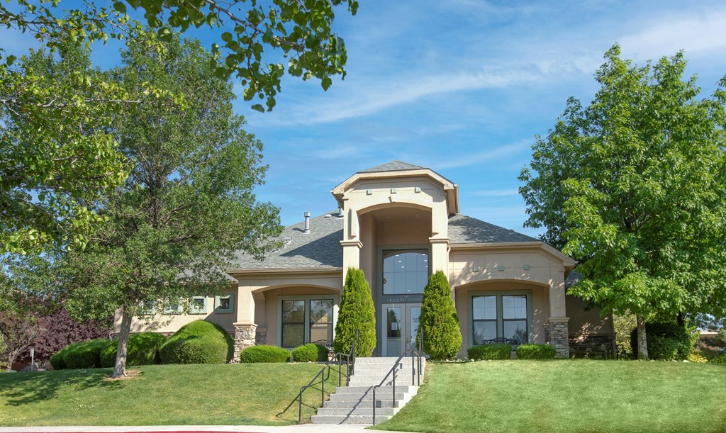 the front of a house with a lawn and trees