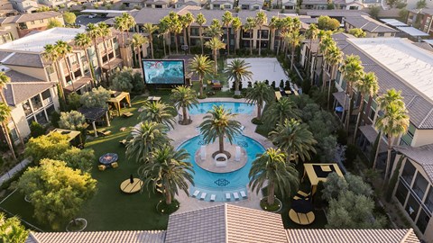 A pool surrounded by palm trees and a screen in the middle.
