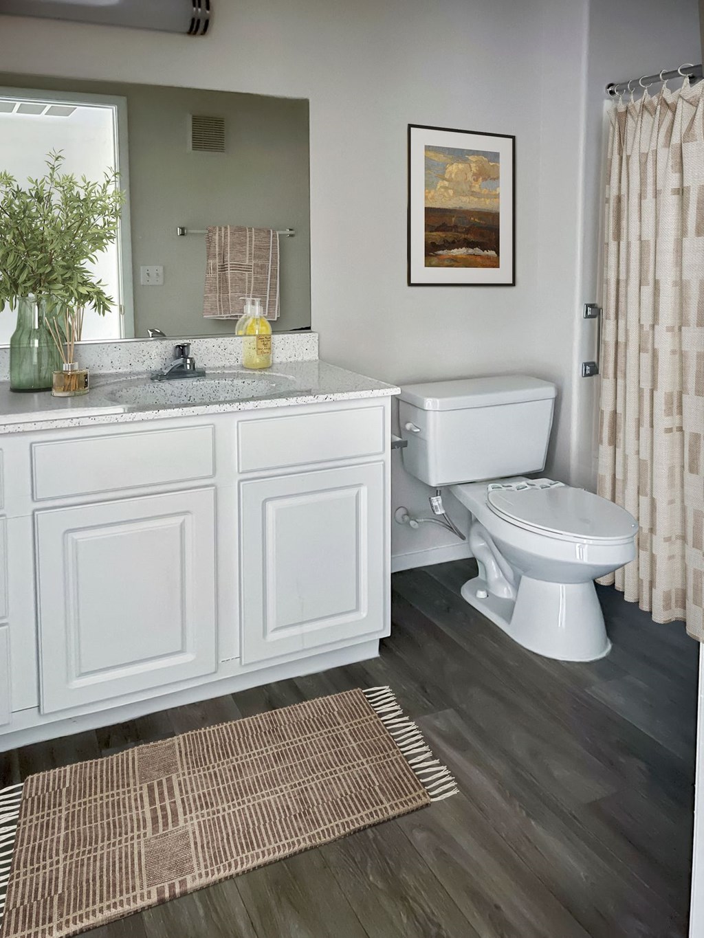 a bathroom with white cabinets and a white toilet