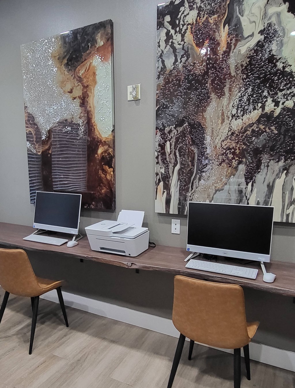 a desk with two laptops and a printer on it