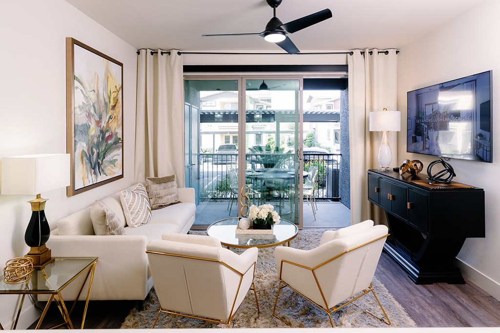 A living room with a white sofa, a coffee table, and a ceiling fan.