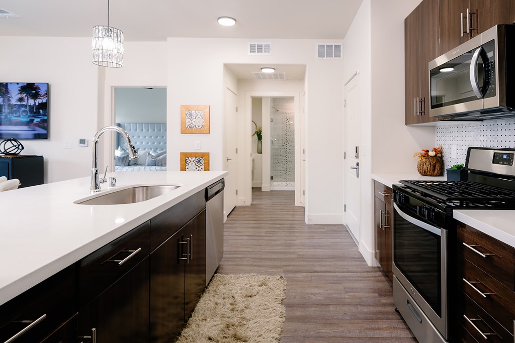 A modern kitchen with dark wood cabinets and stainless steel appliances.