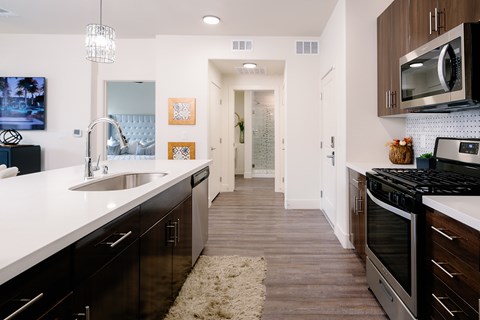 A modern kitchen with dark wood cabinets and stainless steel appliances.
