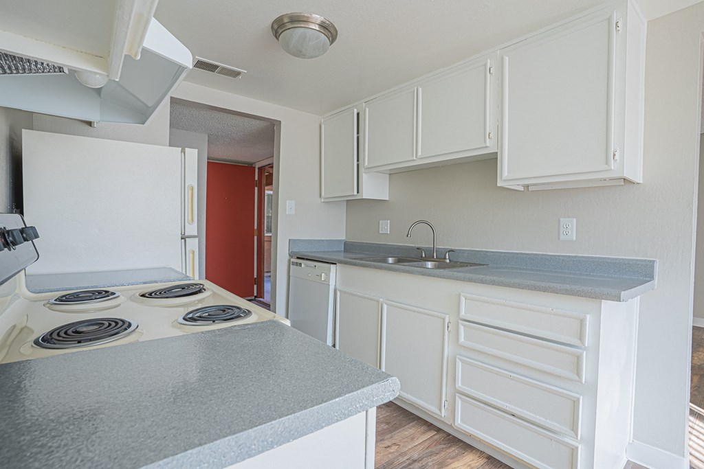a kitchen with white cabinets and a stove and a sink a kitchen with white cabinets and a stove and a sink at Parkside Gardens Apartments, Sparks Nevada