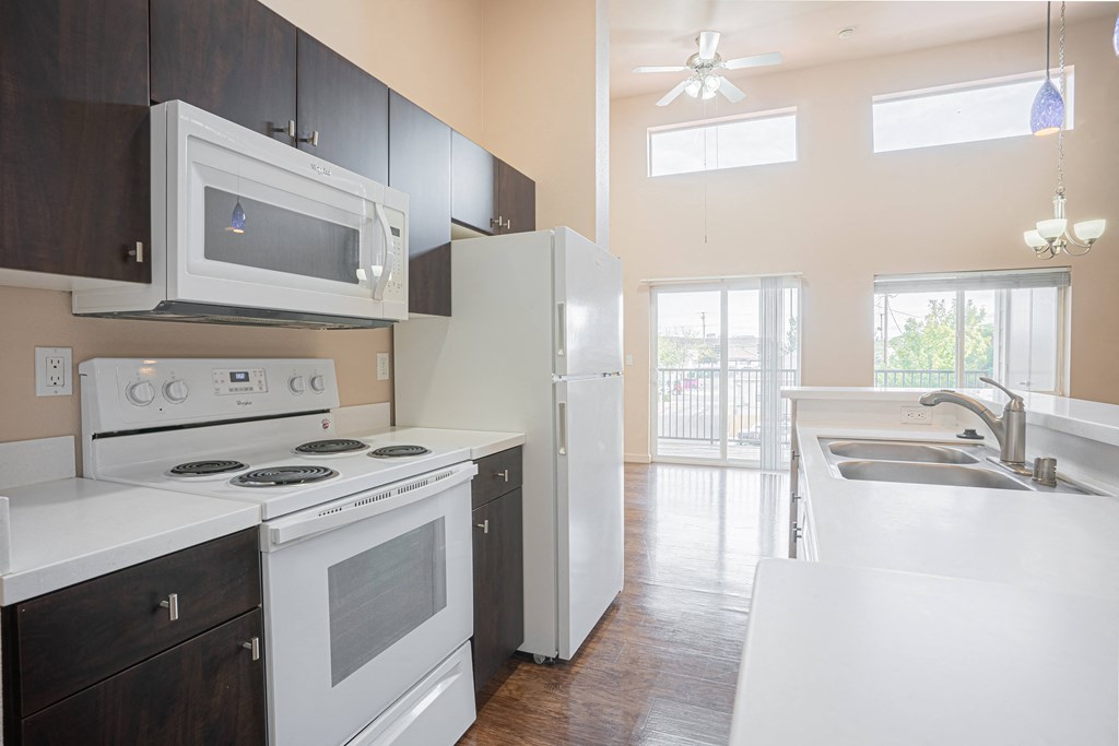 a kitchen with white appliances and black cabinets and a white refrigerator