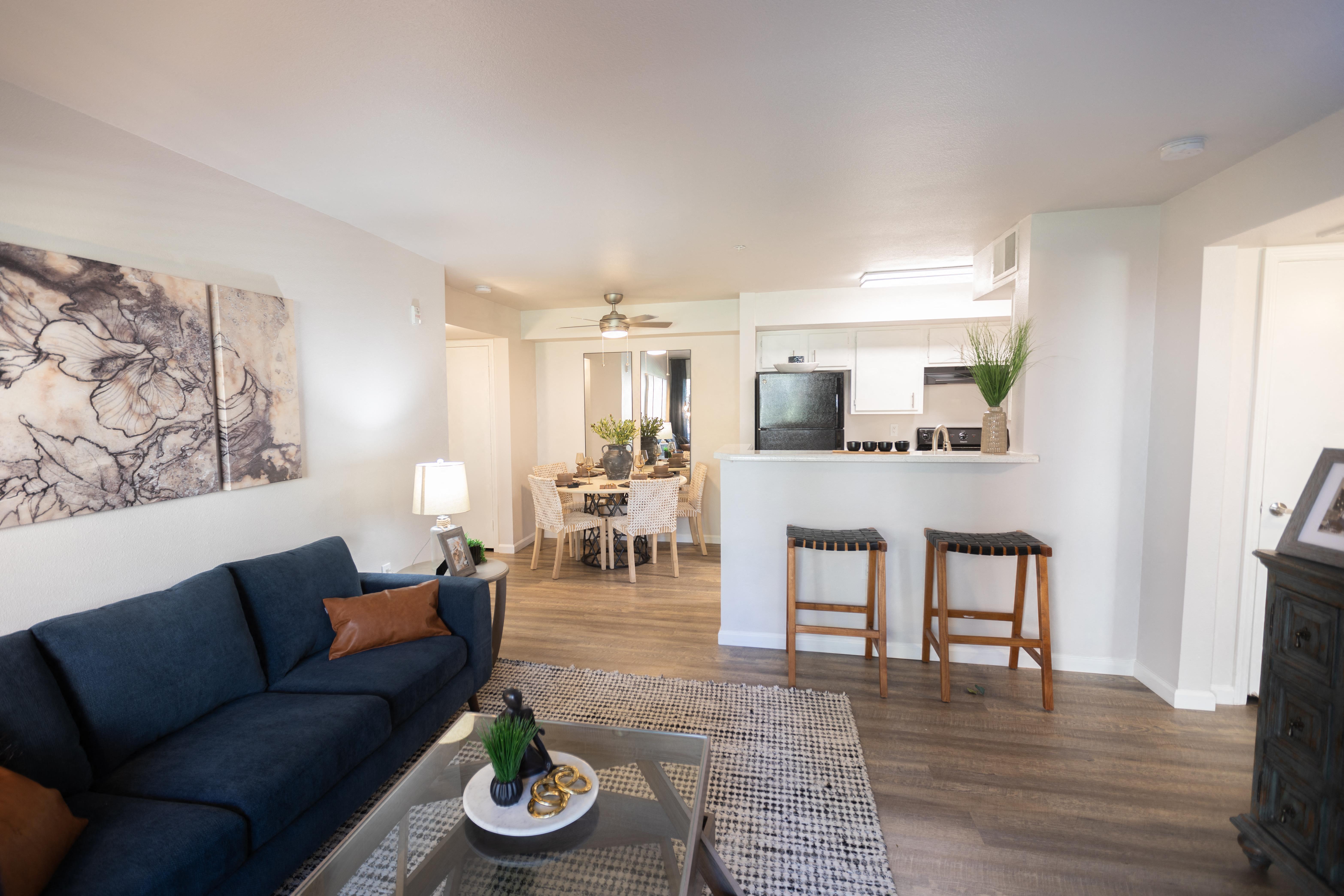 a living room and kitchen with a blue couch and a coffee table at Austin Crest Apartments, Reno, Nevada