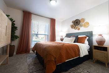 an orange and black bedroom with a bed and a window at Austin Crest Apartments, Reno, 89523