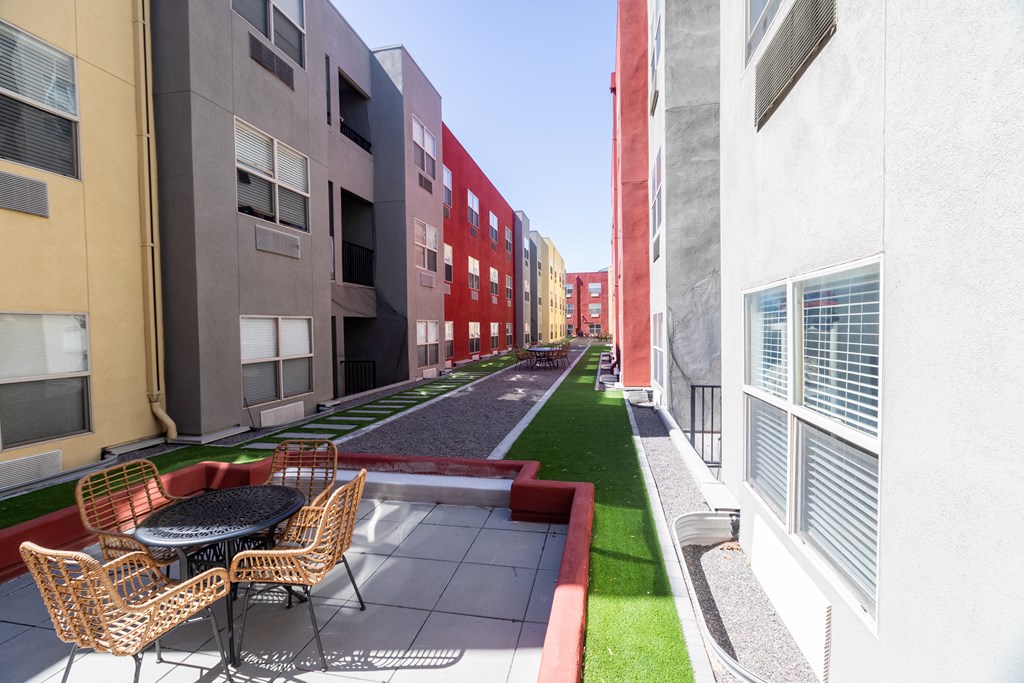 a rendering of a courtyard between two buildings with chairs and a table at ParcOne60, Nevada, 89501