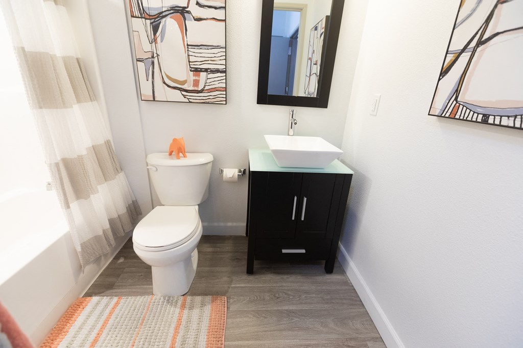 a bathroom with a toilet and a sink and a mirror at ParcOne60, Reno, 89501