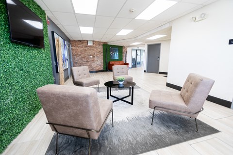 a waiting room with brown chairs and a green wall at The Onyx at 695, Reno