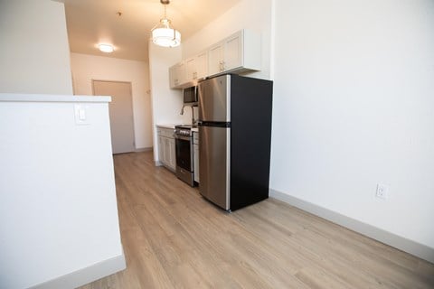 a renovated kitchen with stainless steel appliances and wood flooring in an apartment