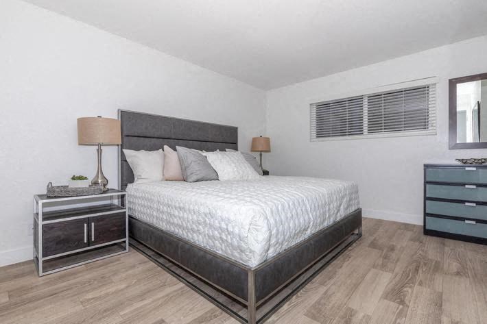 a bedroom with a bed and two night stands at Evoq Apartment Homes, Las Vegas, NV 89169  