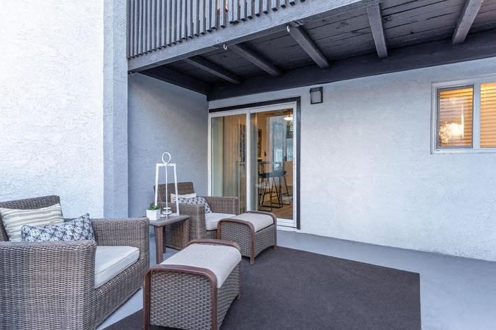 a patio with wicker furniture and a sliding glass door at Evoq Apartment Homes, Las Vegas Nevada  