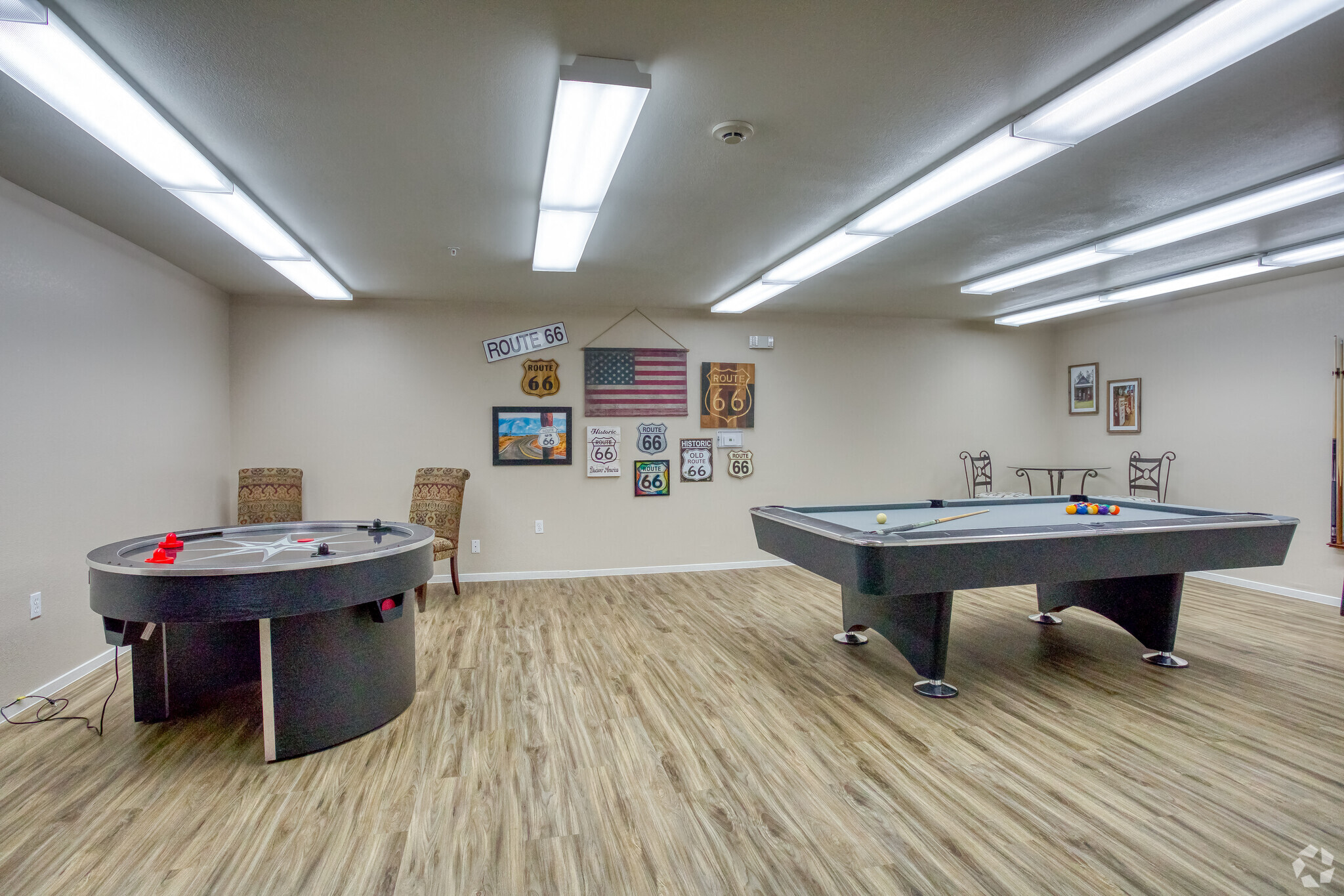 a games room with two pool tables and a wall of artwork