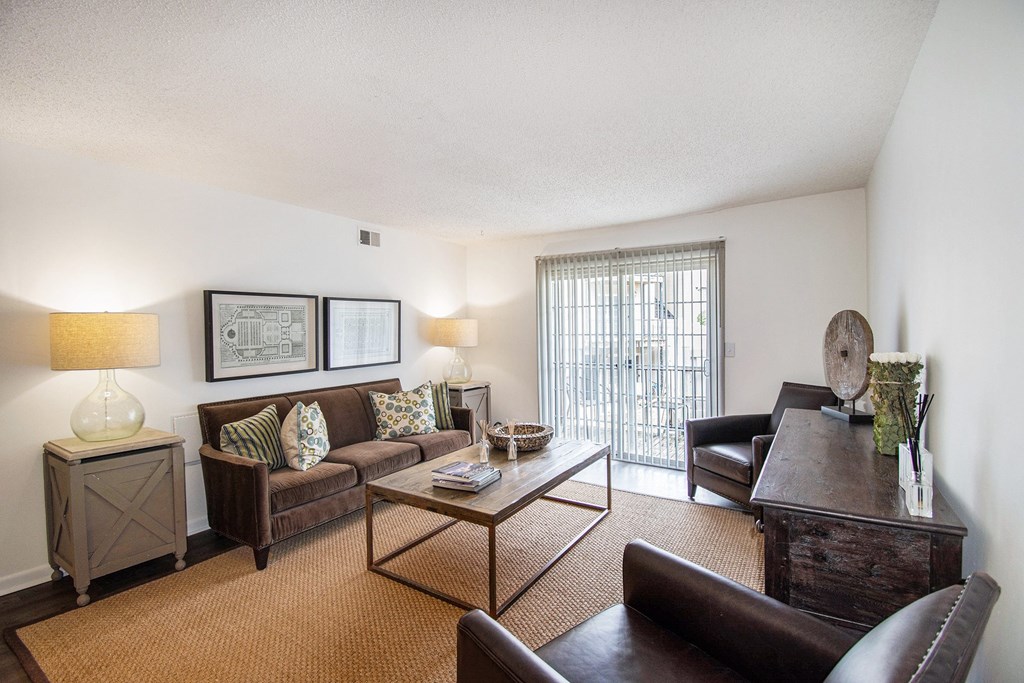 A living room with a brown couch, a coffee table, and a lamp.