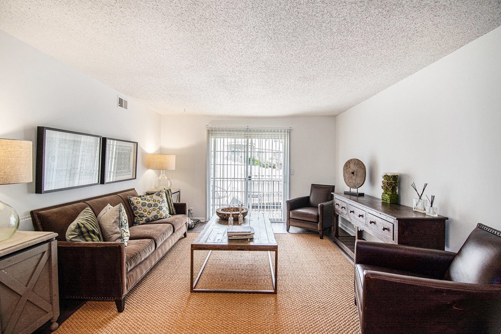 A living room with a brown couch and a coffee table.