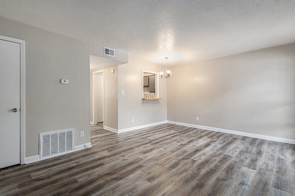 an empty living room with wood flooring and white walls