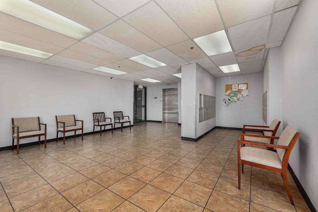 a lobby room filled with chairs and a door